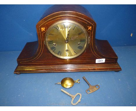 A wooden inlaid cased mantle clock with key and pendulum.