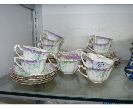 A Foley china part teaset in cream with green and purple floral decoration including teacups, saucers, teaplates etc., some c