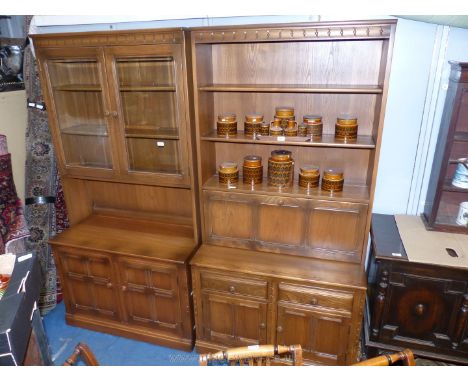 A pair of Ercol Oak display units, one with glazed double doored upper cupboard with plate recess, pair of lower cupboard doo