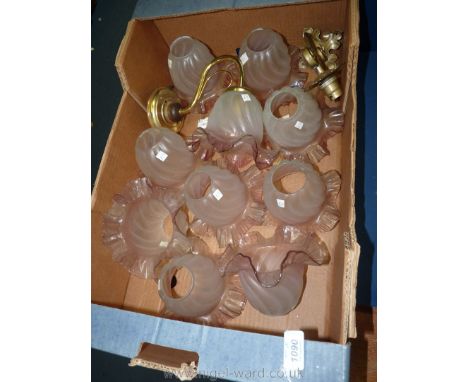 A quantity of pink fluted rim light shades with two brass wall light fittings.