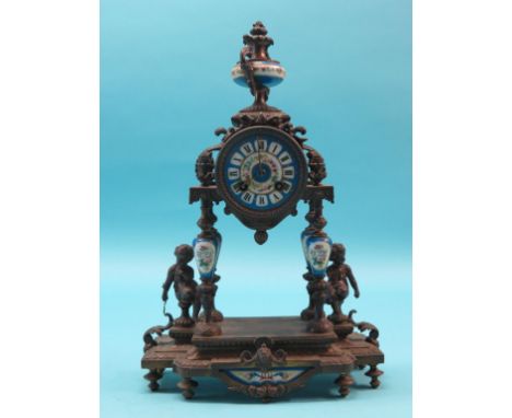 A 19th century French bronzed metal mantel clock, in neo-classical style, porcelain dial and mounts, case cast with seated yo