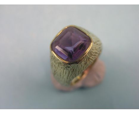 A gentleman's 9ct. gold dress ring, bark-effect with step-cut amethyst, size N, 10.4 grams gross total