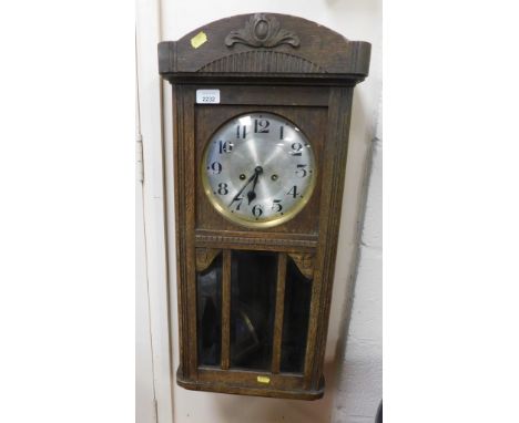 An oak cased wall clock with silvered dial, Arabic numerals to chapter ring.
