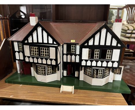 A Tri-Ang mock Tudor two bay doll's house with integral garage. c.1935. Later painted and wired for electric light. 48'w x 24