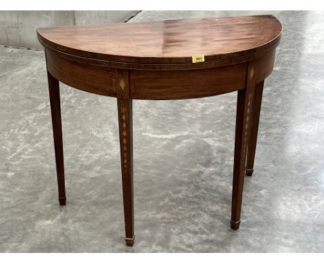 A George III mahogany demi-lune tea table, the square tapered legs inlaid with shells and ribbon-tie harebell pendants. 36' w