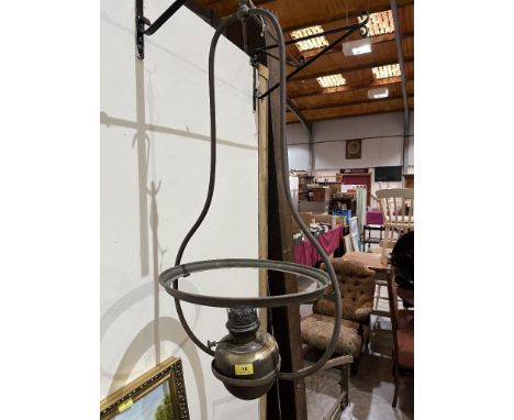 An early 20th century handing oil lamp. 34' high. Shade and chimney lacking