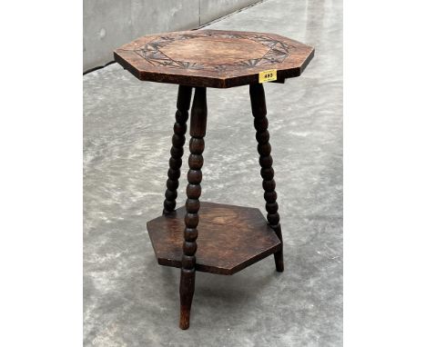 An oak octagonal occasional table with carved top, on bobbin turned splayed legs united by an undertier. 24' high