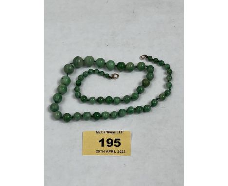 A necklace of graduated jade beads with gold clasp. 16' long 