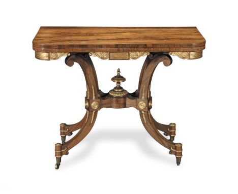 A Regency rosewood and parcel gilt 'scissor-action' card table attributed to George OakleyCirca 1820, the sliding hinged top 