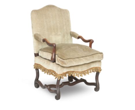 A French early 18th century Louis XIV walnut fauteuilWith scrolled downswept arms, on channelled S-scroll legs, with a shaped