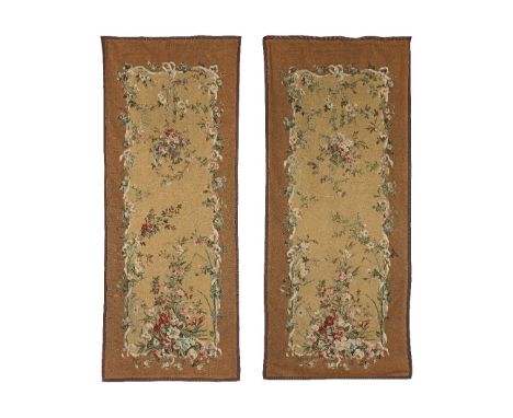 A pair of early 20th century French tapestry panelson caramel ground, the central field with ribbon tied floral swags termina