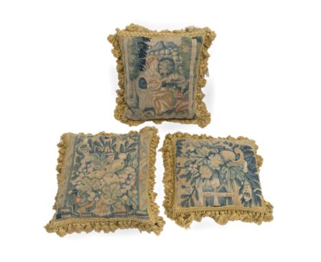 A set of three Flemish tapestry cushions17th century, probably Oudenaarde, one depicting a female musician against a verdant 