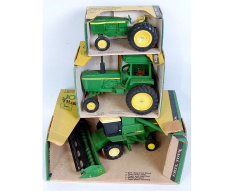 Three boxed ERTL large heavy pressed steel and diecast John Deere tractor and combine groups, to include; Titan combine, Util