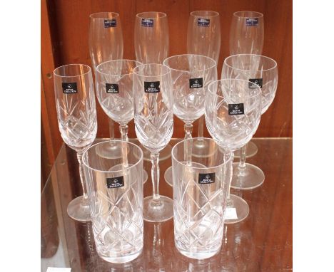 A small collection of twelve assorted drinking glasses, comprising a set of four champagne flutes baring Royal Worcester stic