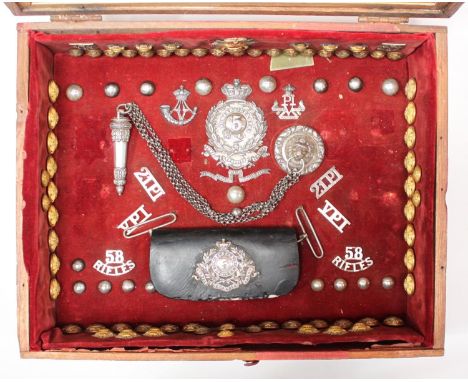 A glazed wooden cased display of badges, buttons and dress items relating to the 58th Vaughanâ€™s Rifles of the British India