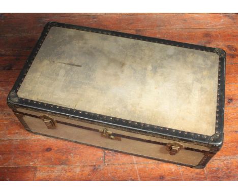 A faded green steamer trunk with brass studded decoration, brass locks and handles to each side, the canvas lined interior ba