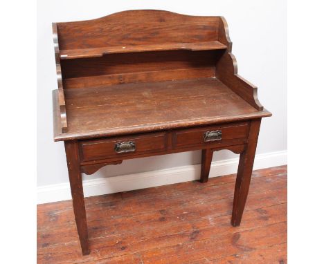 An early 20th century stained oak dressing table, with three-quarter shaped gallery, two frieze drawers with art nouveau hand