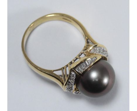 An 18ct gold dress ring set with a central South Sea pearl surrounded by fourteen baguette and eighteen round brilliant-cut d