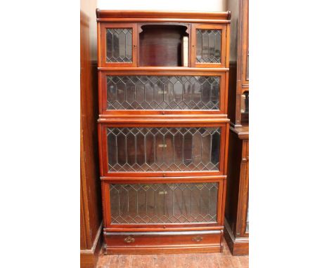 A mahogany Globe Wernicke four-section bookcase with leaded glazed doors, 'Globe Wernicke Co Ltd' labels, the top tier with o