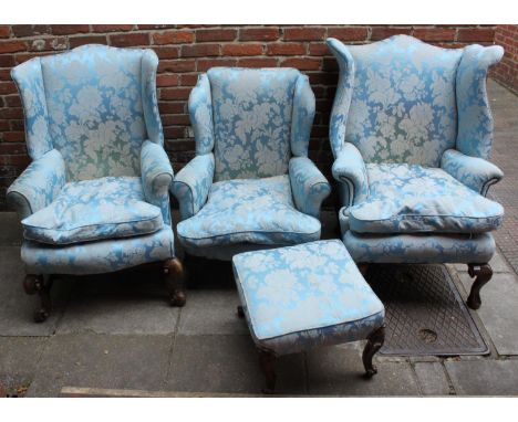 Three various Victorian wing-backed armchairs and a pouffe, all upholstered in blue damask fabric 