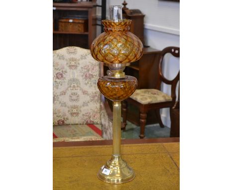 A glass and brass oil lamp, caramel glass globular shade and reservoir, double burner, reeded column, circular base