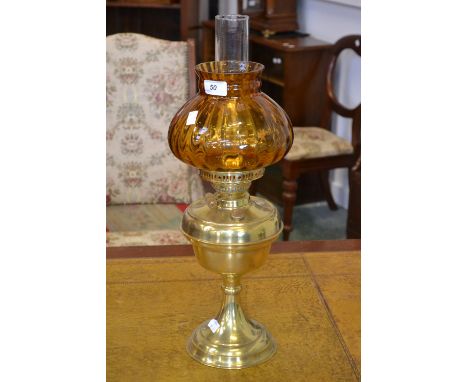 A brass and glass oil lamp, amber onion shade, double Duplex burner, brass reservoir