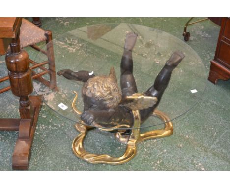 A contemporary bronze and brass effect Cupid coffee table, circular glass top