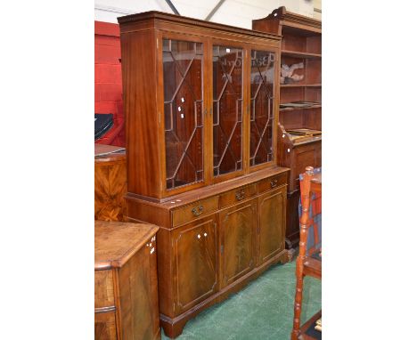 A mahogany sideboard, dentil cornice over three astragal glazed doors enclosing shelving top top, projecting base, three shor