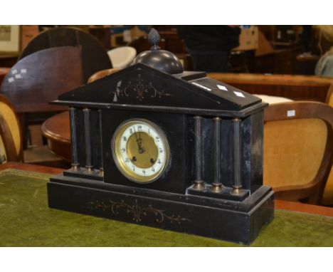 A black slate mantel clock, architectural pediment, brass face with enamelled chapter ring and Arabic numerals, flanked by si