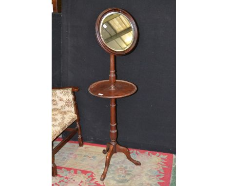 A George III mahogany shaving stand, hinged circular mirror, round shelf, turned column, tripod base