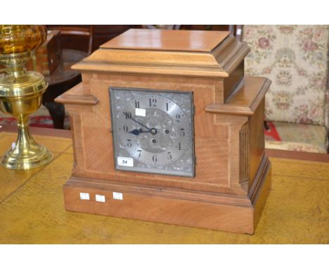 An architectural light oak mantle clock,Arabic numerals, the silvered dial engraved with flowering foliage, Fattorini and Son