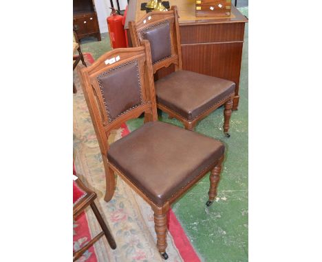 A pair of Victorian mahogany dining chairs, arched top rail, padded back and seat, turned forelegs ceramic castors