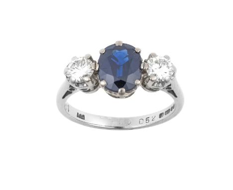 An 18 Carat White Gold Sapphire and Diamond Three Stone Ringthe oval cut sapphire flanked by round brilliant cut diamonds, in