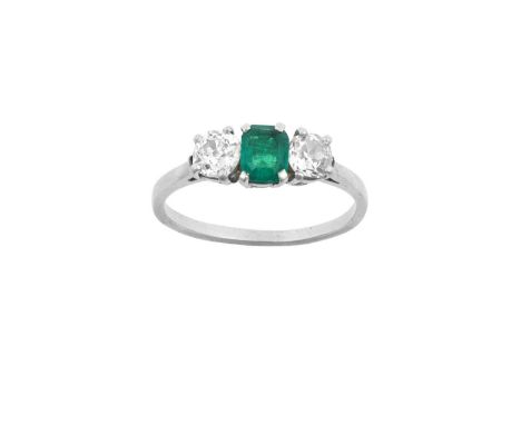 An Emerald and Diamond Three Stone Ringthe emerald-cut emerald flanked by old cut diamonds, in white claw settings, to a tape