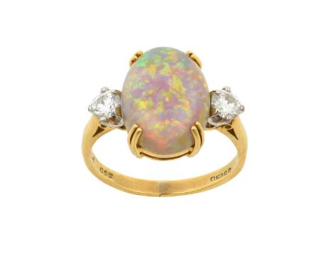 An 18 Carat Gold Opal and Diamond Three Stone Ringthe oval cabochon opal in a yellow double claw setting, flanked by round br