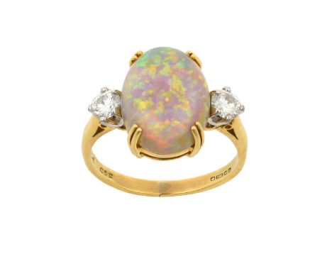 An 18 Carat Gold Opal and Diamond Three Stone Ringthe oval cabochon opal in a yellow double claw setting, flanked by round br