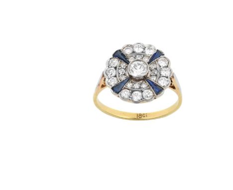 A Synthetic Sapphire and Diamond Cluster Ringthe central raised round brilliant cut diamond within a double border of round b