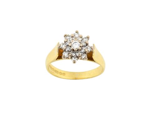 An 18 Carat Gold Diamond Cluster Ringthe central raised round brilliant cut diamond within a double stepped border of eight-c