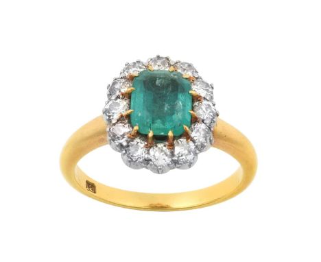 An Emerald and Diamond Cluster Ring the emerald-cut emerald in a yellow claw setting, within a border of old cut diamonds in 