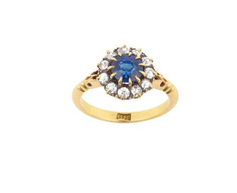 A Sapphire and Diamond Cluster Ringthe round cut sapphire within a border of old cut diamonds, in yellow claw settings, to a 