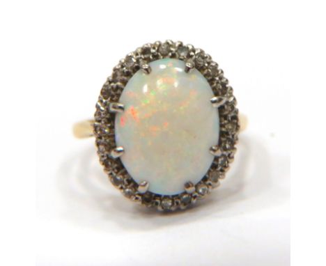 Stunning Opal Set ring with Diamond surround set on an 18ct Yellow Gold shank. Opal Measures 14 x 10 mm.   Finger size 'P'   