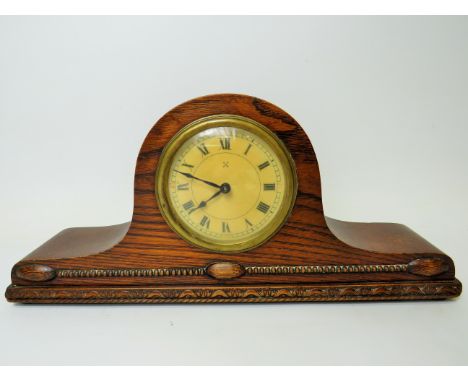 Oak cased mantle clock with ornate carving to the base. Brass mechanism in running order. Measures 14 inches long by 6.5 inch