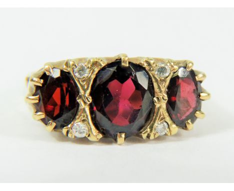 9ct Yellow Gold Gypsy Style Ring set with a Large Central Oval Garnet which measures approx 10 x 8 mm and flanked by two smal