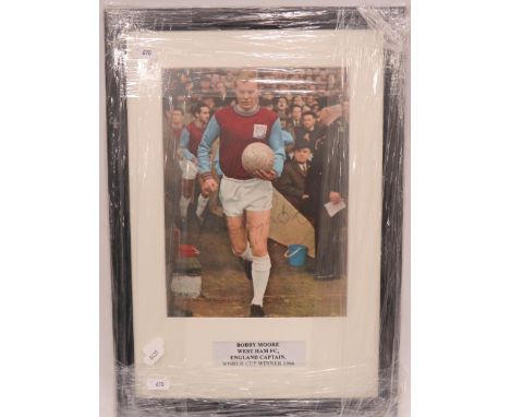 Framed and mounted under glass print of Bobby Moore which has the players Autograph on the photo.  Measures approx 17 x 12 in
