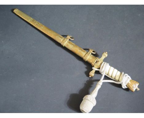 A WWII German Kriegsmarine Dagger with scabbard, blade stamped PUMA, grip cracked and slight dents to scabbard 
