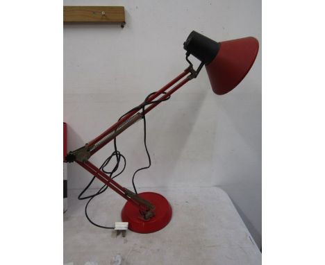An angle poise style lamp in red with weighted base