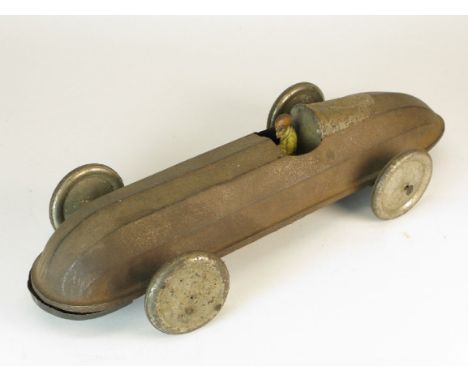 *Floor Toy. A racing car toy with manual operated axles rear and front,  with a pressed tin driver, but the windscreen missin