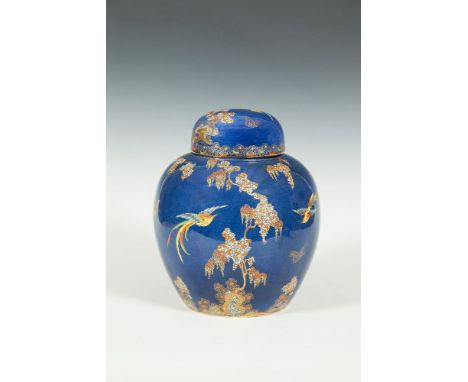 A CARLTONWARE BLUE GROUND JAR AND COVER, c.1920, gilded and enamelled with colourful trees, rocks and exotic birds. 26cm high