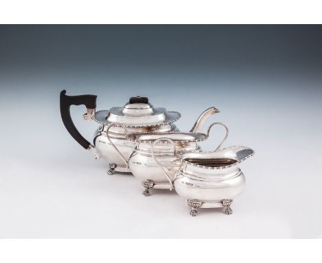 A SILVER THREE PIECE TEA SERVICE, Sheffield, comprising teapot, sugar bowl, cream jug, each of oblong form, with bead and ree