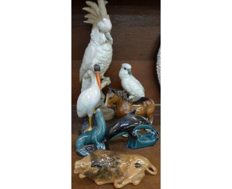 A Royal Dux figure of a cockatoo, a Mackay figure of a parrot, a/f, a Carlton ware heron, beak a/f, a Sylvac lion, a Poole po